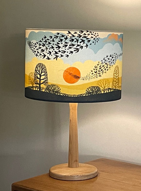 A table lamp with an autumn theme shade